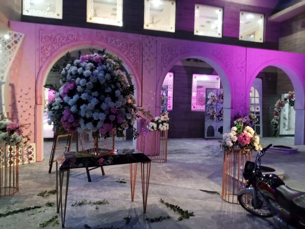 Arched hall interior with a large floral arrangement on a slim gold stand