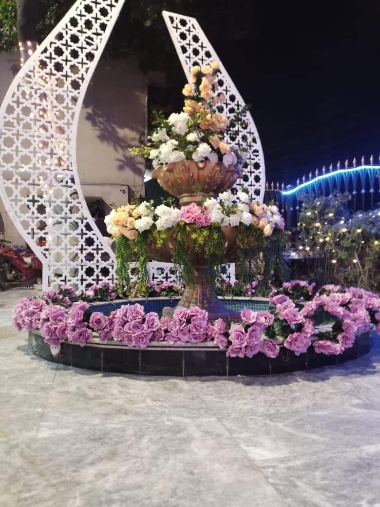 White lattice screen with a raised urn of pink and cream roses at Ahmed Palace