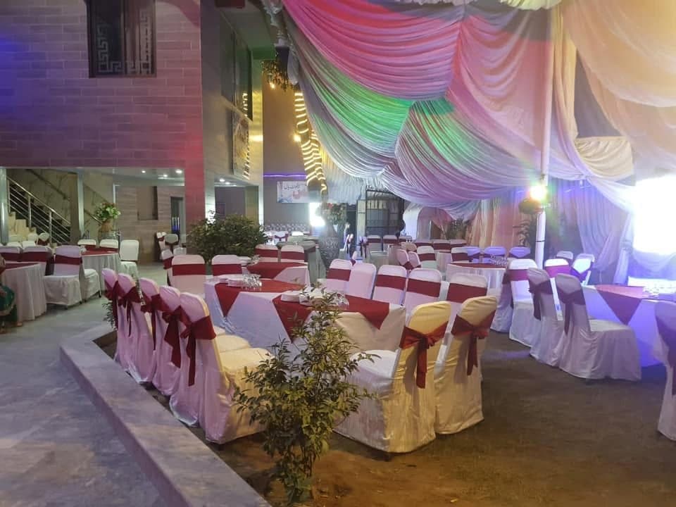 Covered chairs with maroon sashes arranged around banquet tables at Ahmed Palace