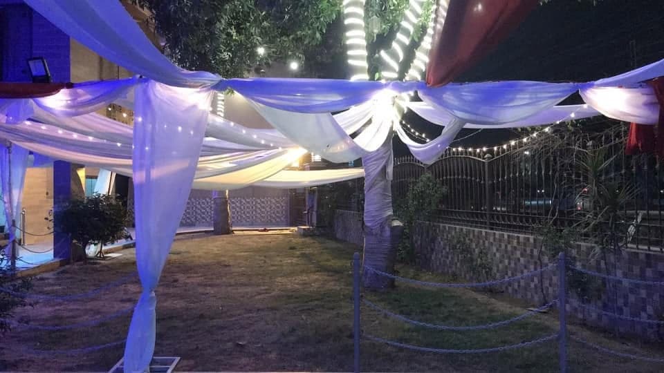 Outdoor area at Ahmed Palace with white drapery strung between trees and lights