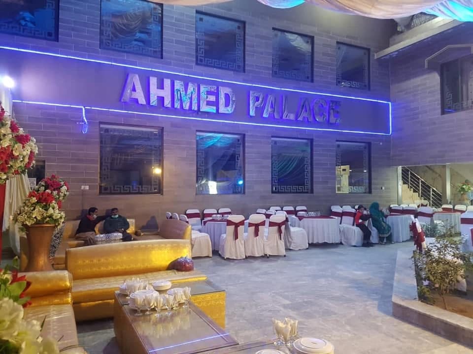 Outdoor marquee at Ahmed Palace with white draping and the illuminated venue sign