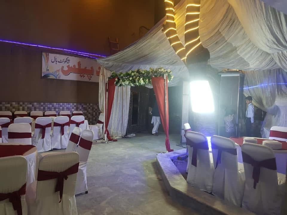 Stage set against draped fabric and coloured lighting in the marquee