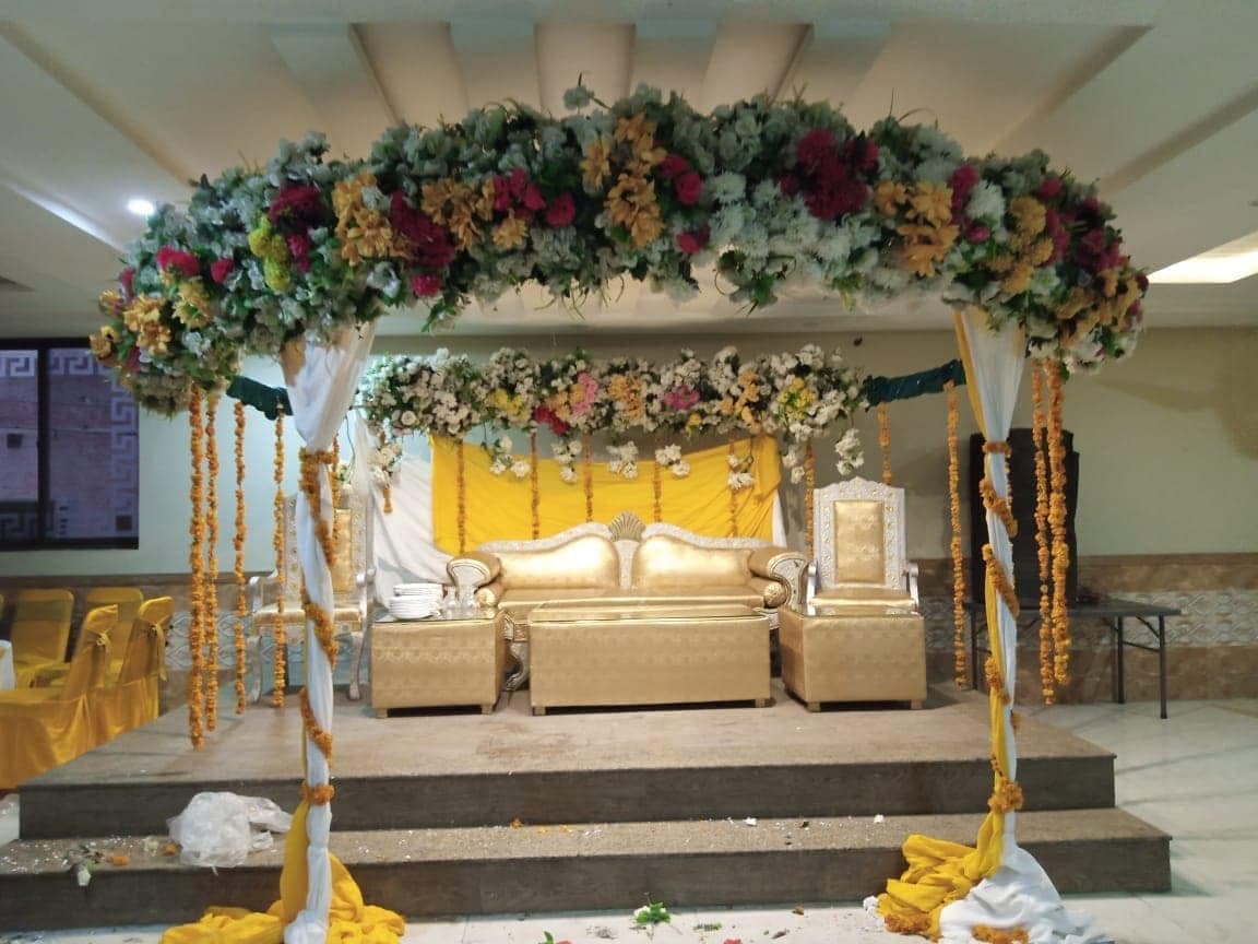 Mehndi setup at Ahmed Palace with a flower-covered pergola and marigold hangings